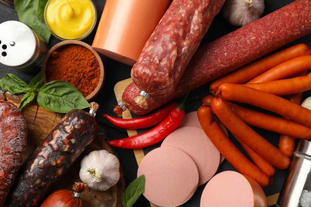 Top view of board of cured meats with garlic, spices and herbs