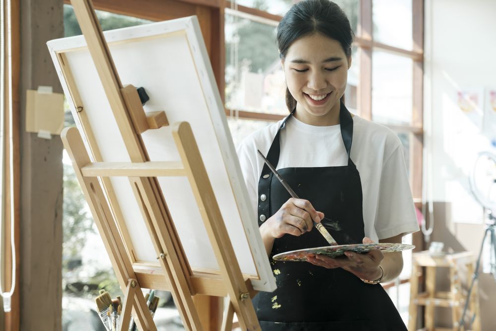 Crafting Inspiration. Female Artist Sketching and Painting in Workshop