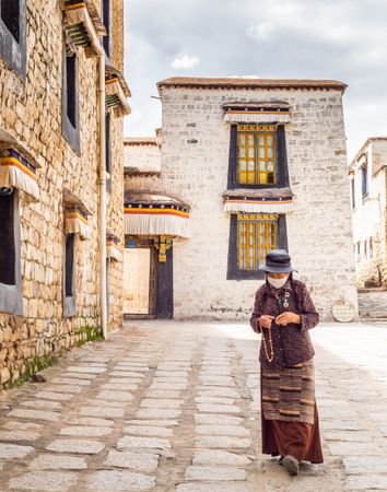 Tibet - August, 29 2014: woman in mask walking on street