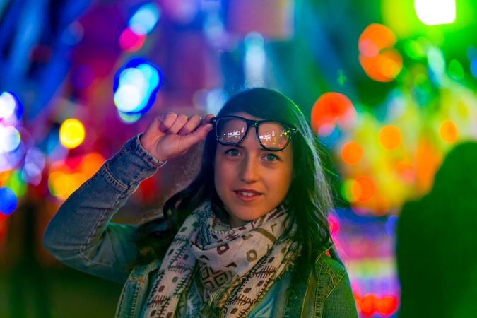 Stylish young woman near illumination on street
