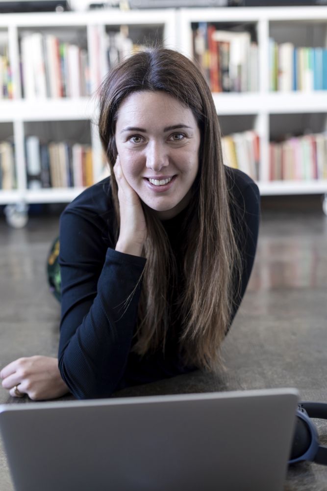 Young entrepreneurial woman using a laptop while sitting on floor