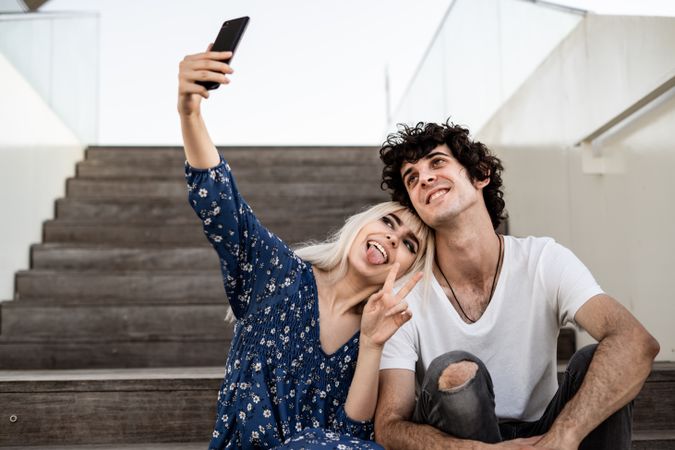 Happy couple taking selfie on street