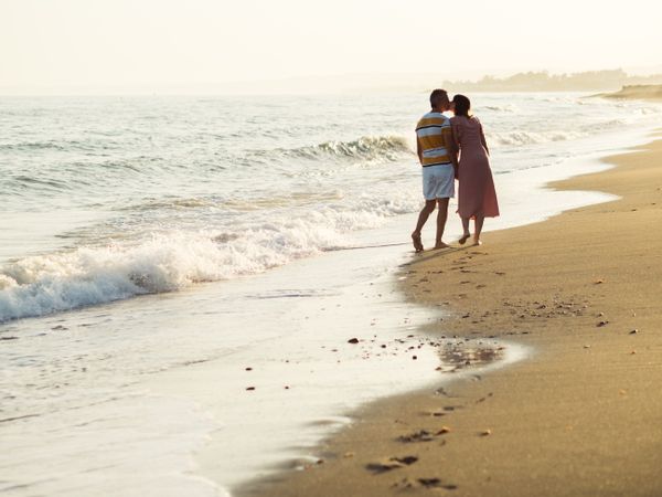 Adult couple walking towards sea