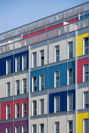 Facade of modern multicolored building with narrow windows