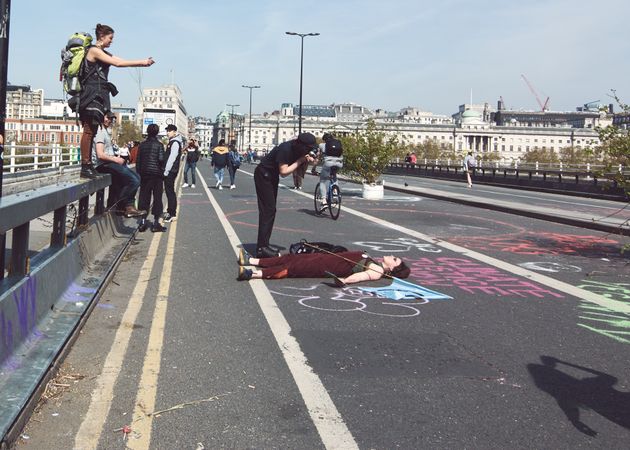 London, England, United Kingdom - April 19th, 2019: Woman lies on street as onlookers take photos
