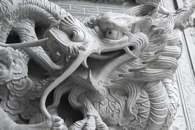 A wall with dragon stone sculpture in chineese temple.