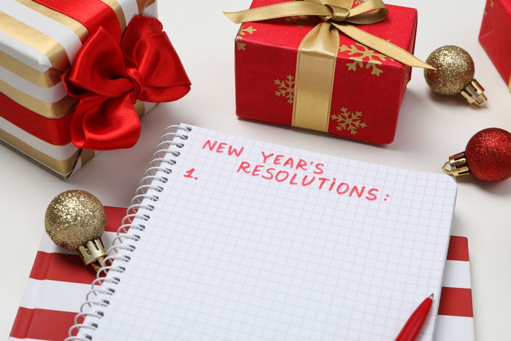 Gift boxes and notepad with text on light background, close up