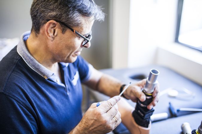 man fixing a prosthesis in a workshop