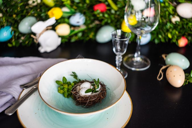 Delicate decorative nest in bowl on Easter table setting