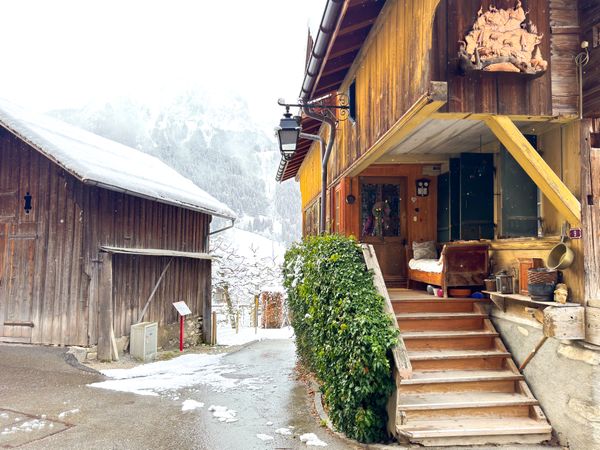 Traditional Swiss chalet steps to the entrance in snowy Rougemont, VD