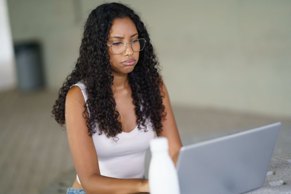 A Focused Woman is Intently Engaged in Productive Work on Her Laptop in a Modern Office Environment