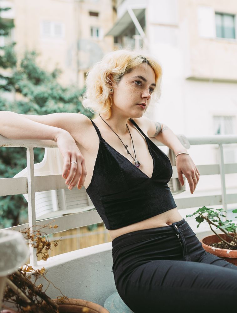 Charming calm woman resting on balcony in summer