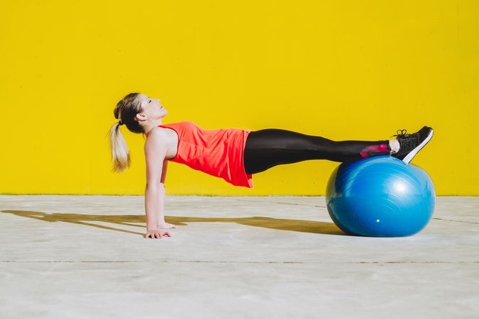 Woman doing plank with legs on ball