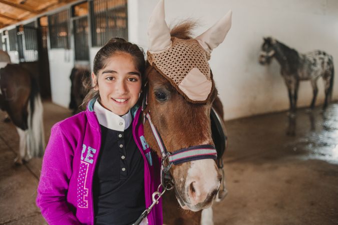 Girl with adorable pony in hat