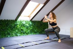 Woman doing squats in attic