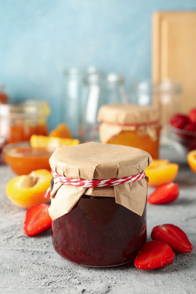Composition with jam and ingredients on gray table, space for text