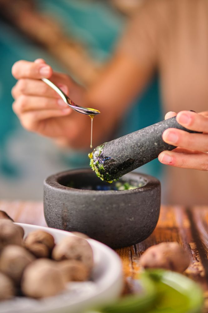 Unrecognizable female adding oil to sauce
