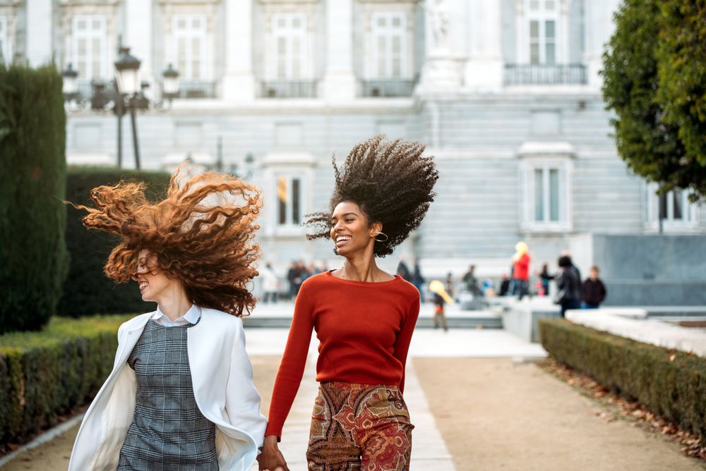 Two cheerful young women walking together