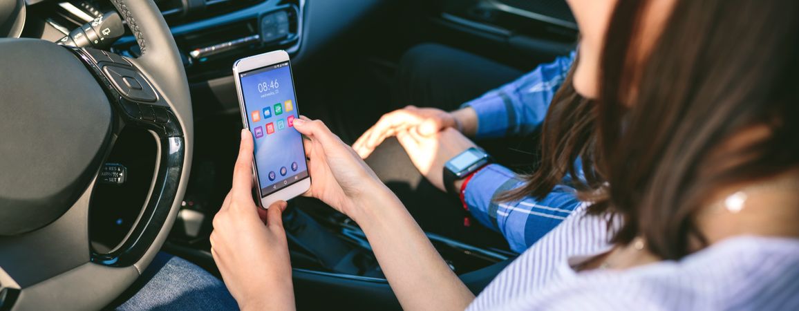 Woman and boyfriend using mobile in the car