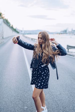 Long haired stylish woman taking selfie with smartphone