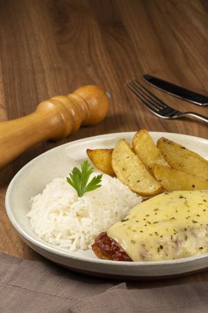 Parmigiana steak with rice and roasted potatoes. Typical Brazilian dish.