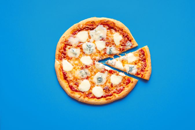 Sliced pizza top view on a blue background