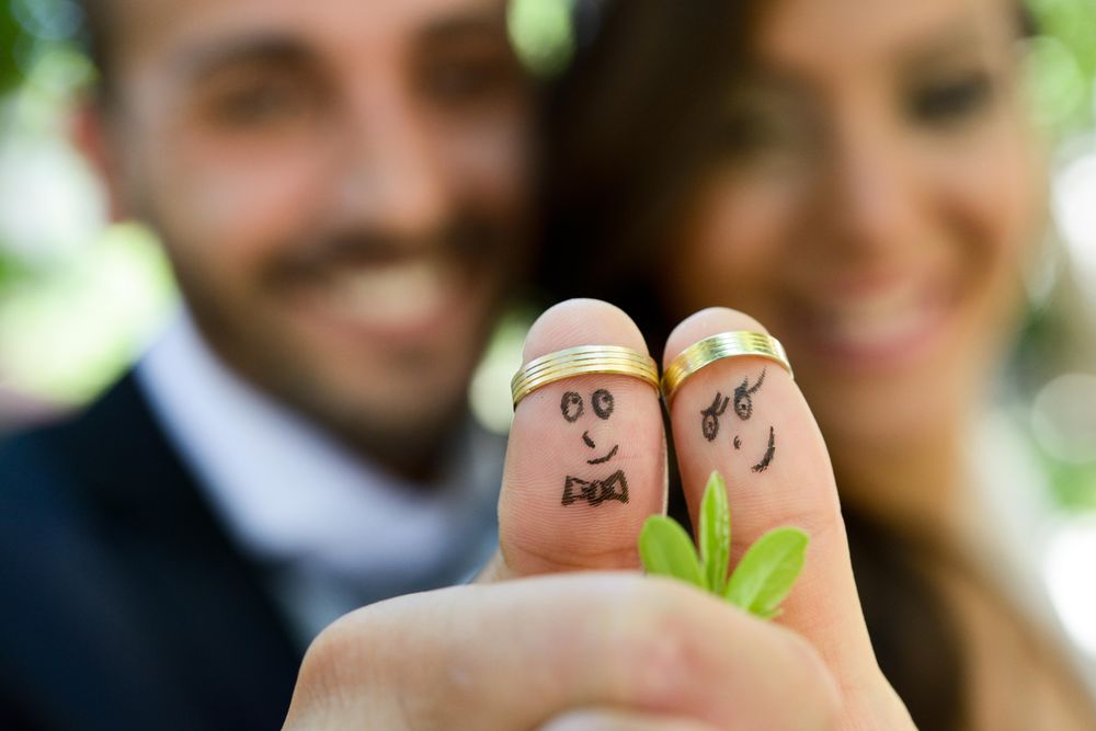 Thumbs with funny painted on fingers with wedding rings