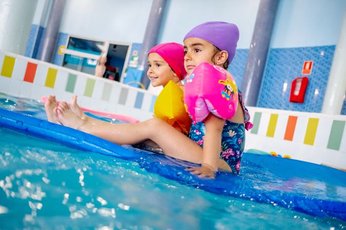 girls with water wings in swimming pool