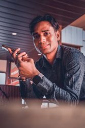 Man in dress shirt holding smartphone