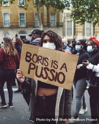 London, England, United Kingdom - June 6th, 2020: Woman in mask with sign disparaging politician 0PjZv4
