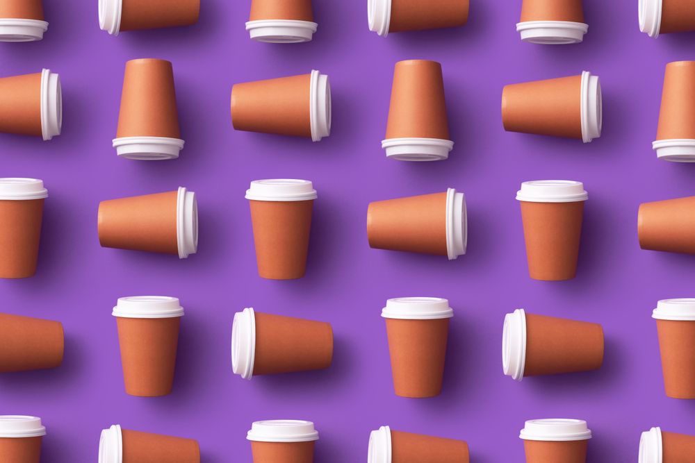 Pattern of disposable coffee cups on purple background