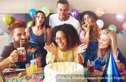 Group Of People Celebrating Their Friends Birthday As She Blows Out ...