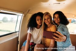 Three women taking a selfie in the back of a van bxmQn0