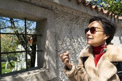 Mature elegant woman smoking a marijuana pipe outside