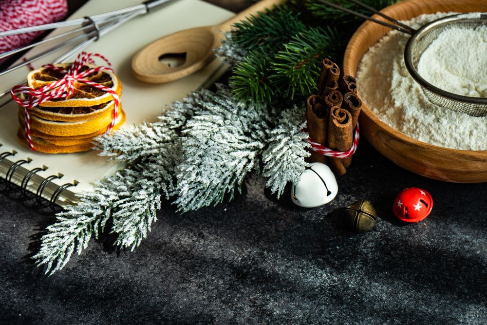 Flour and ingredients for Christmas baking on dark counter