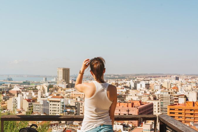 Woman on balcony looking at city views from above