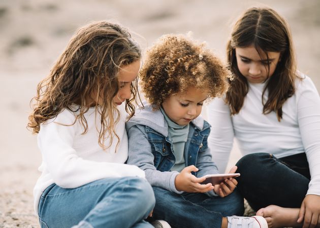 Focused children watching smartphone on nature