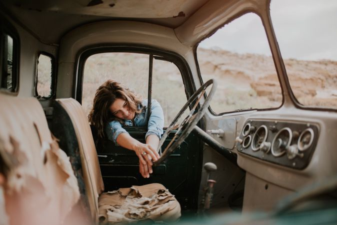 Relaxed female leaning on old truck