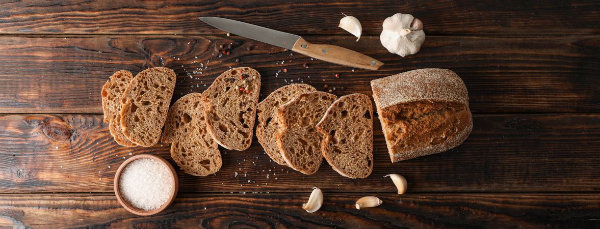 Flat lay composition with freshly baked bread on wooden background, top view and space for text