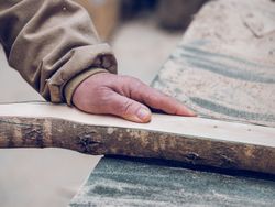 Unrecognizable craftsman with wooden piece