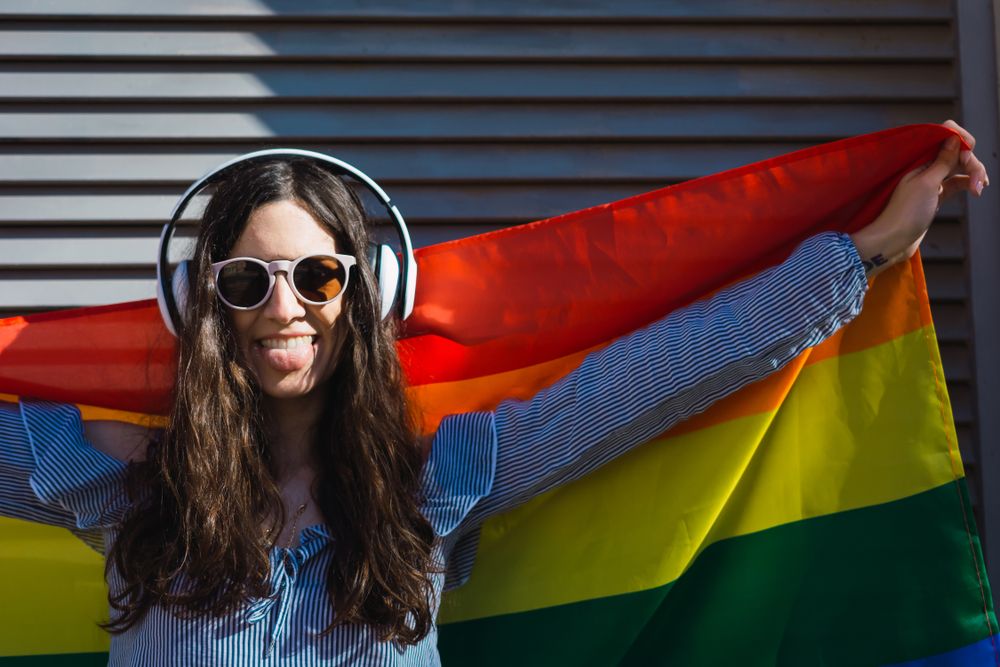 Female posing happily with the LGBT flag