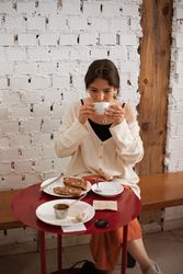 Peaceful woman drinking coffee while resting at home