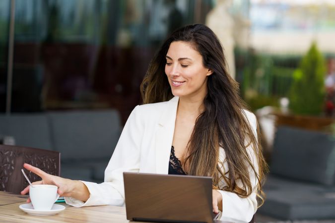 Young Professional Woman Working in a Caf with Laptop and Coffee