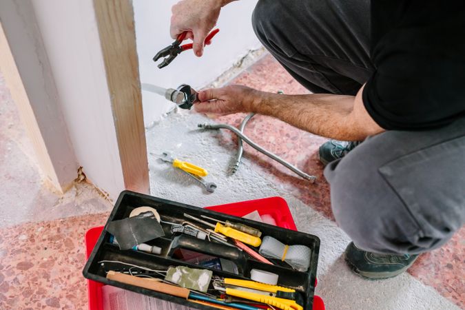 Plumber doing heating installation on a construction site