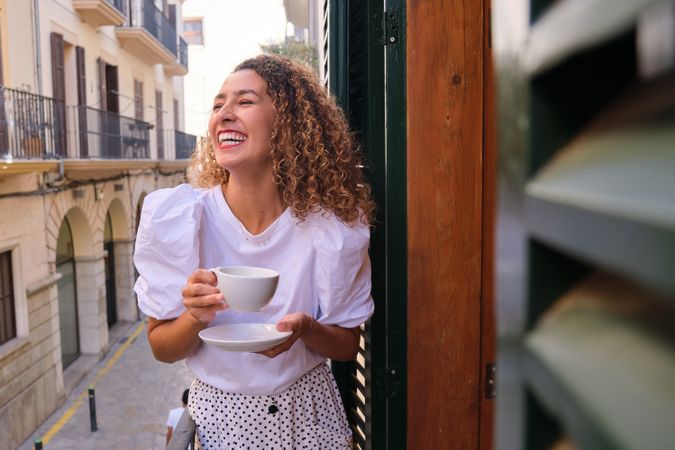 Woman drinking coffee on balcony