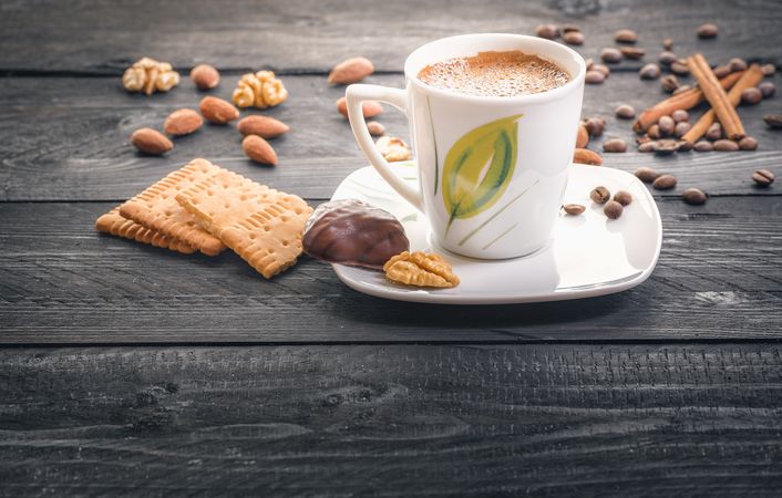 Cup of coffee and snacks on wooden table