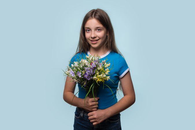 Young girl holding colorful bouquet of flowers