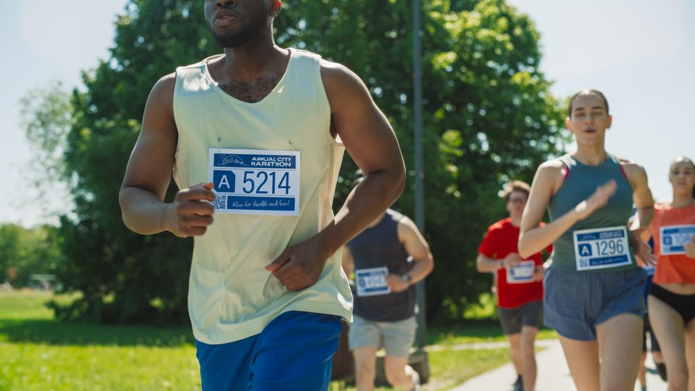 Close Up Portrait of a Black Athletic Male Running a Marathon in a City During the Day in Green Park Trail.
