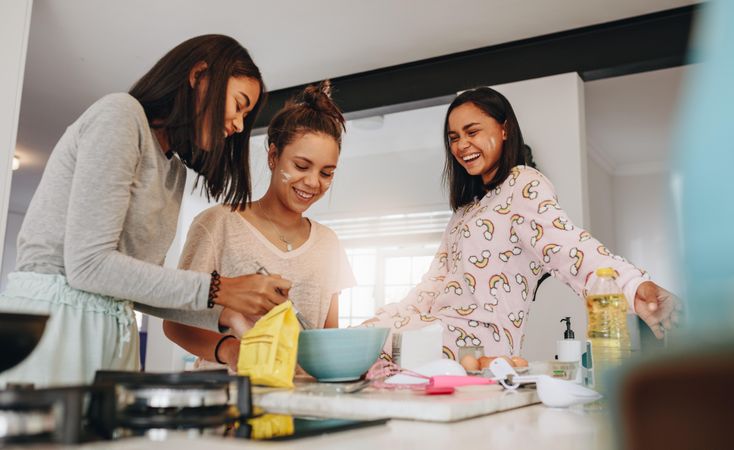 Group of girls having fun preparing breakfast together in kitchen