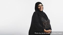 Smiling arabic woman in eyeglasses and hijab looking at camera 5R1X20